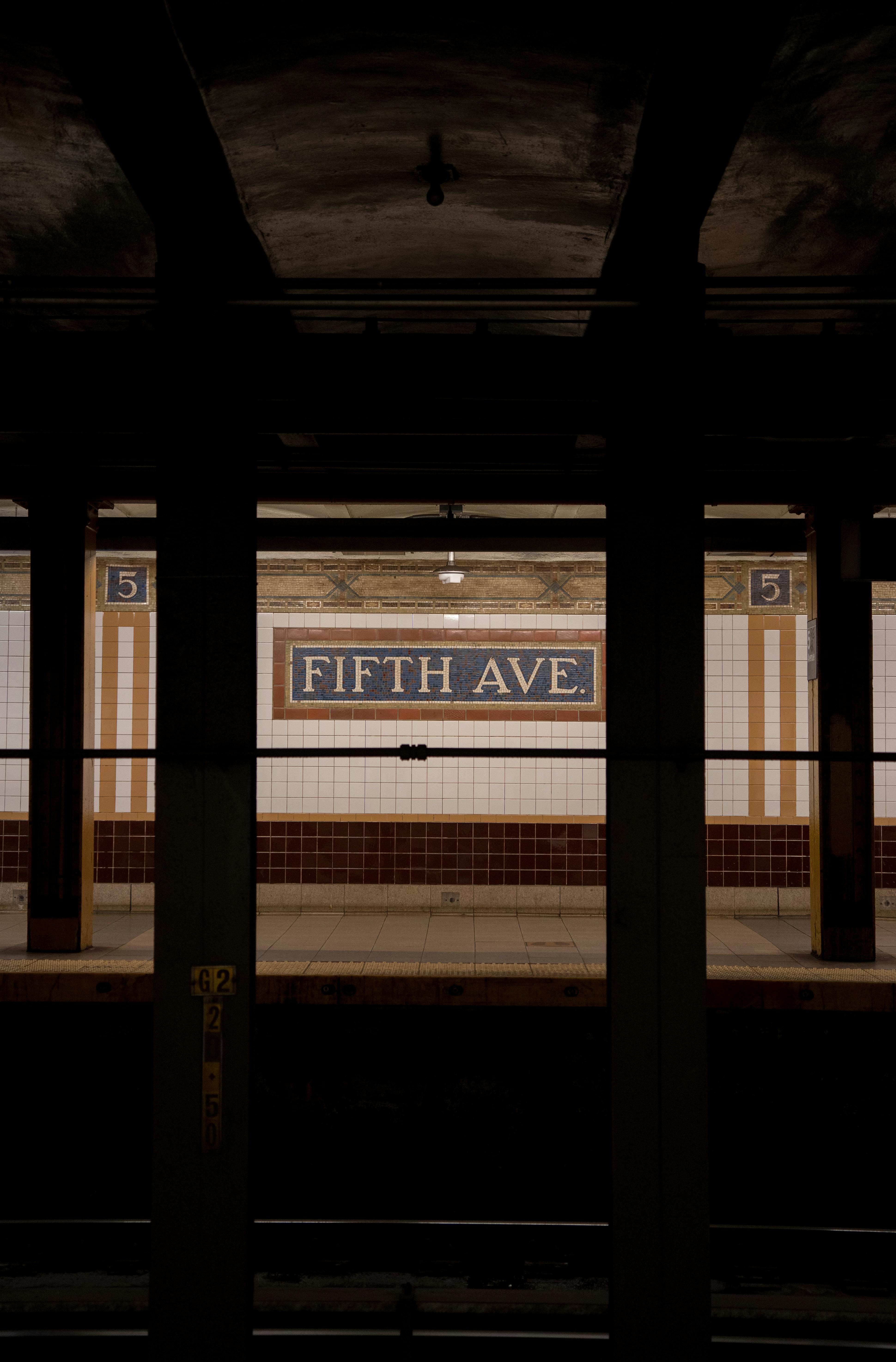 Dark urban view of Fifth Avenue subway station in New York City.