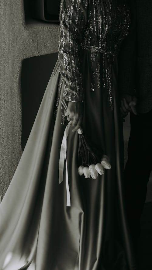 Woman in an Elegant Dress Holding a Bouquet of Tulips