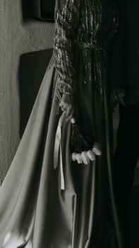 Black and white photo of a woman holding a tulip bouquet in an elegant dress, capturing a sense of sophistication and style.
