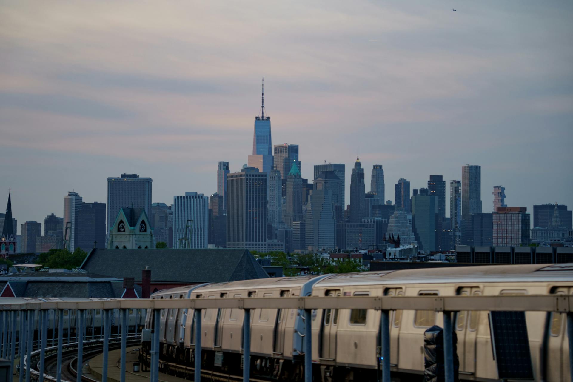 Capture of New York City skyline with subway train in the foreground during daytime.