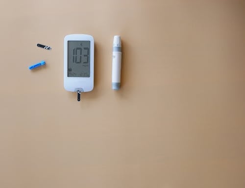 A blood sugar meter and a pen on a table