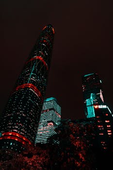 Vibrant illuminated skyscrapers in Guangzhou captured at night, showcasing modern architectural marvels in a stunning cityscape.