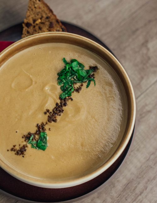 Free Delicious creamy soup garnished with herbs, served with rustic bread, perfect for a cozy meal. Stock Photo