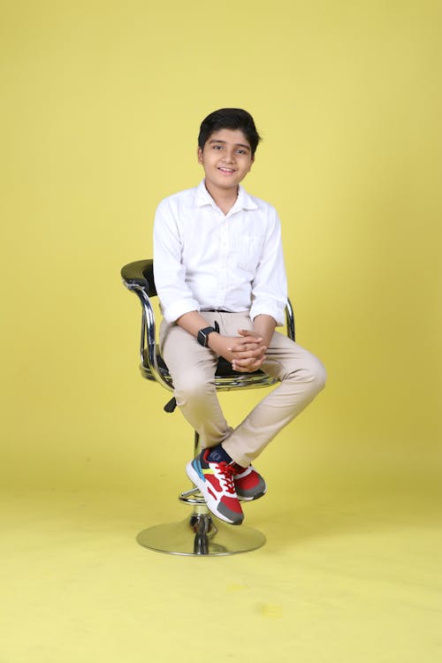 Studio Portrait of a Teenager Boy Sitting in a Rotating Chair