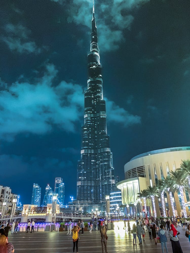 People Standing Near High-rise Building During Night Time