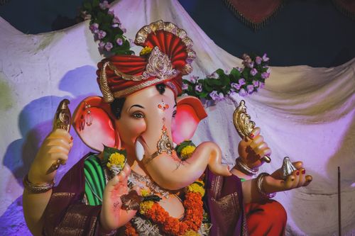Free Colorful Ganesha statue adorned with flowers and decor, symbolizing Hindu traditions. Stock Photo