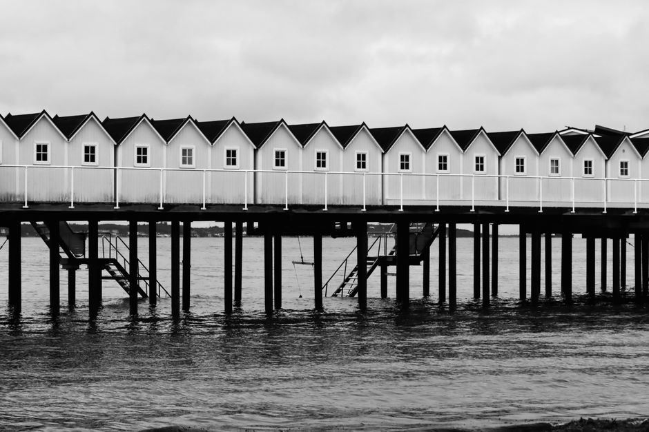 Black and white photo of a waterfront bathhouse pier in Helsingborg, Sweden. Captivating architecture.