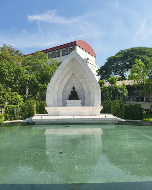 Buddha Statue in White Marble Shrine on the Edge of the Pool