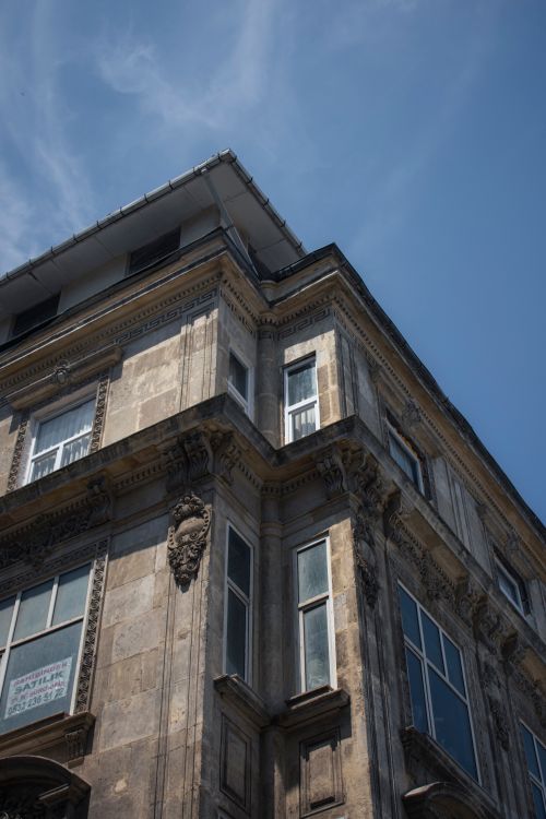 Free Low angle view of a baroque-style building facade in an urban setting under a clear blue sky. Stock Photo