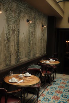 Charming restaurant interior featuring vintage wallpaper and beautifully set tables creating a cozy ambiance.