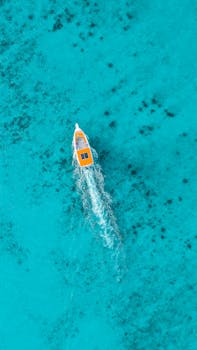 Aerial view of a motorboat navigating through vibrant turquoise waters in Bayahíbe, Dominican Republic.