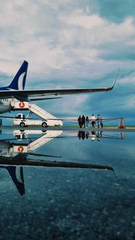 A Turkish Airlines plane on a tarmac with a dramatic sky reflection, shot at Sivas Airport.