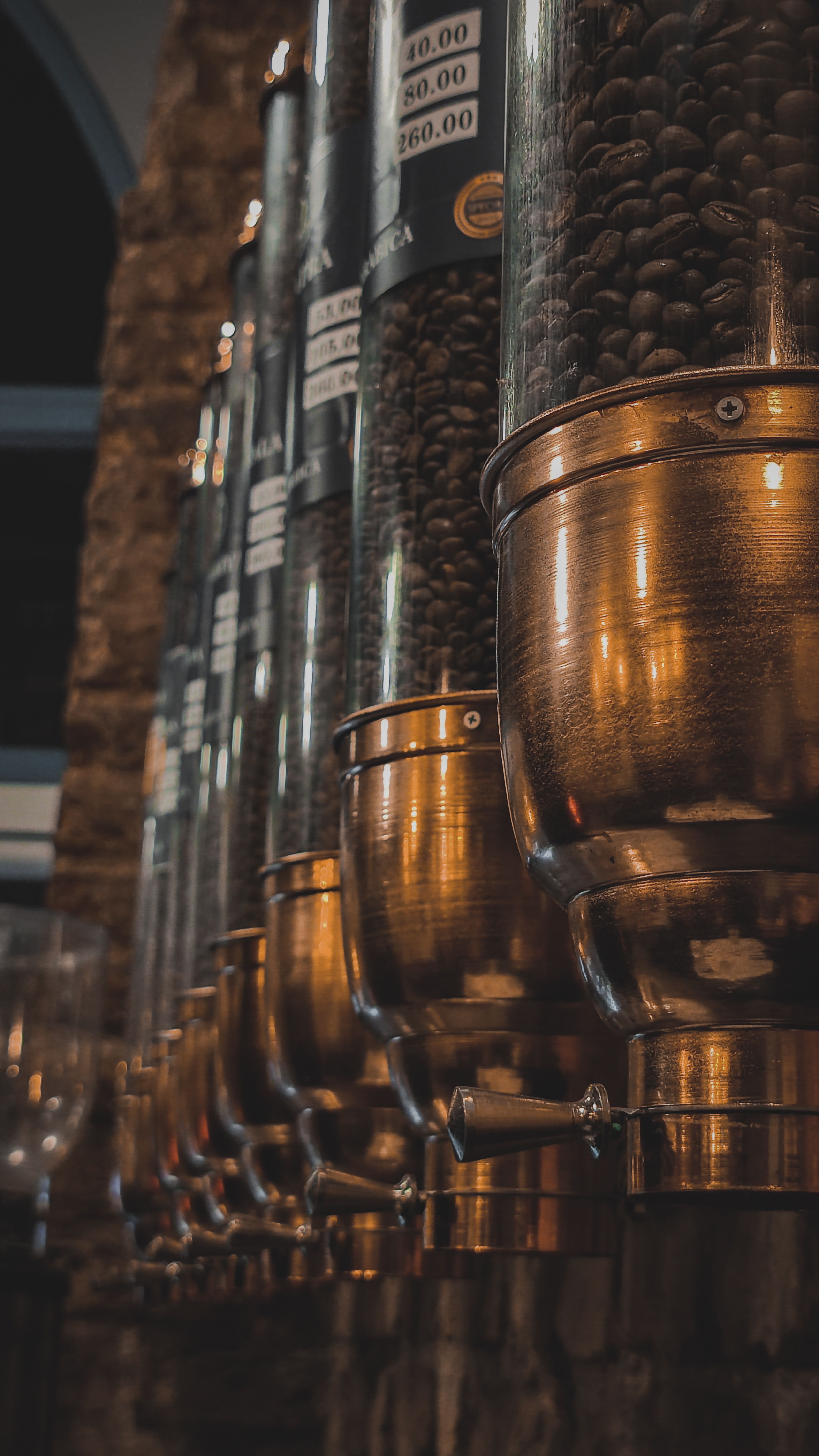 A detailed view of coffee dispensers showcasing coffee beans, perfect for café ambiance.