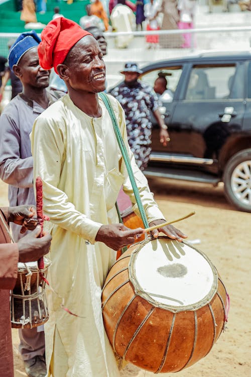 Men in Traditional Clothes Playing Drums