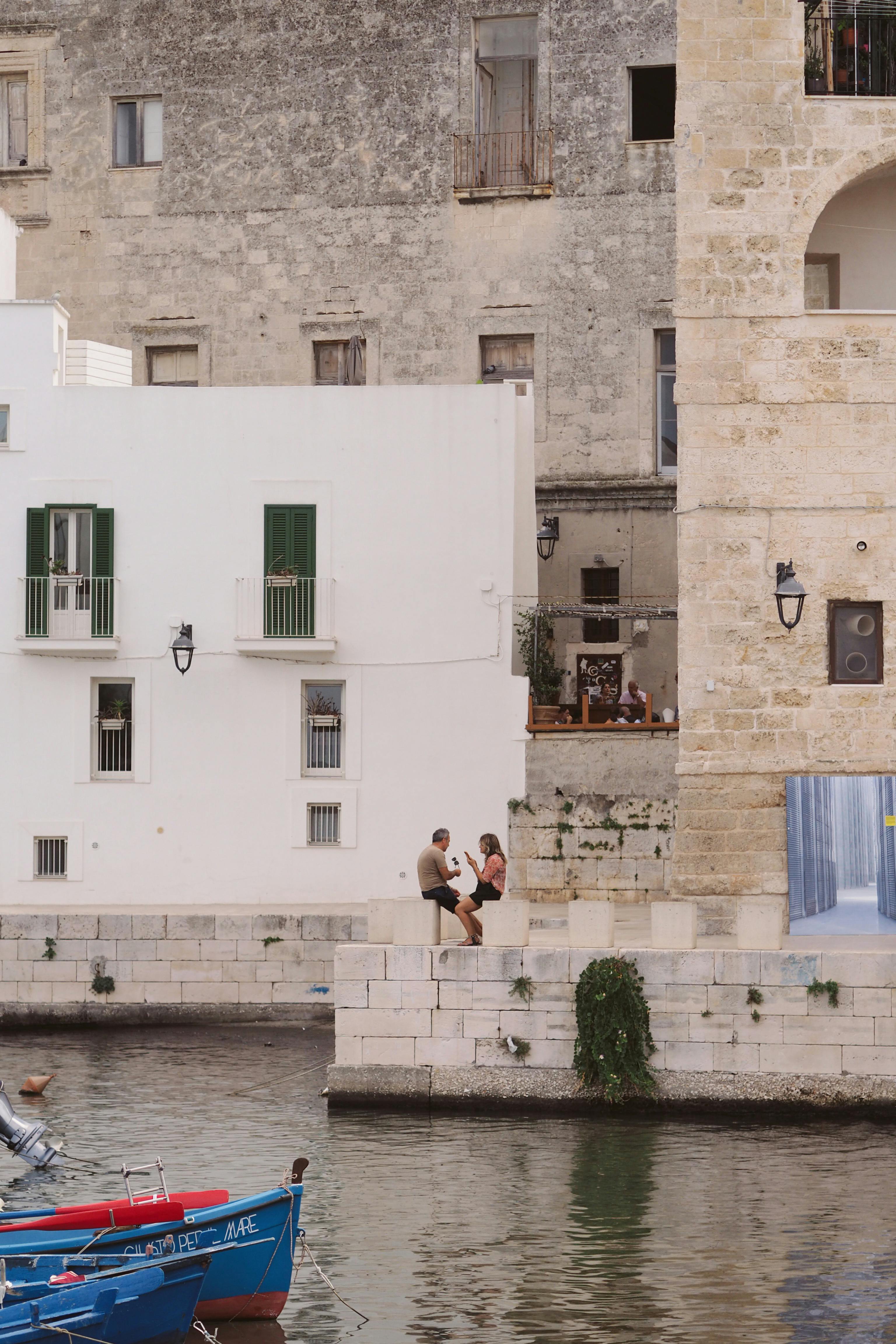 Couple enjoying a picturesque canal view in a historic European town.