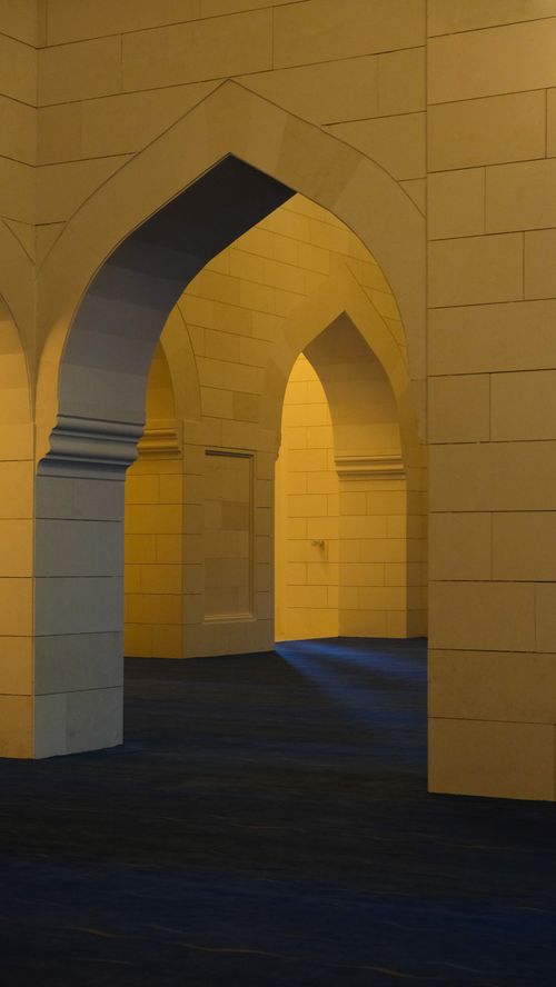 Free A serene interior view showcasing elegant arches with a navy blue floor and yellow walls. Stock Photo