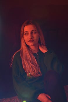 一位身着绿色毛衣的体贴女人，在变幻的灯光下优雅地摆着姿势