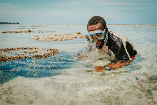 Man snorkeling in clear Zanzibar waters, capturing marine beauty.