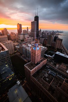 从空中俯瞰芝加哥，日落时分的天际线令人惊叹，充满活力的色彩映衬着标志性的摩天大楼和城市建筑