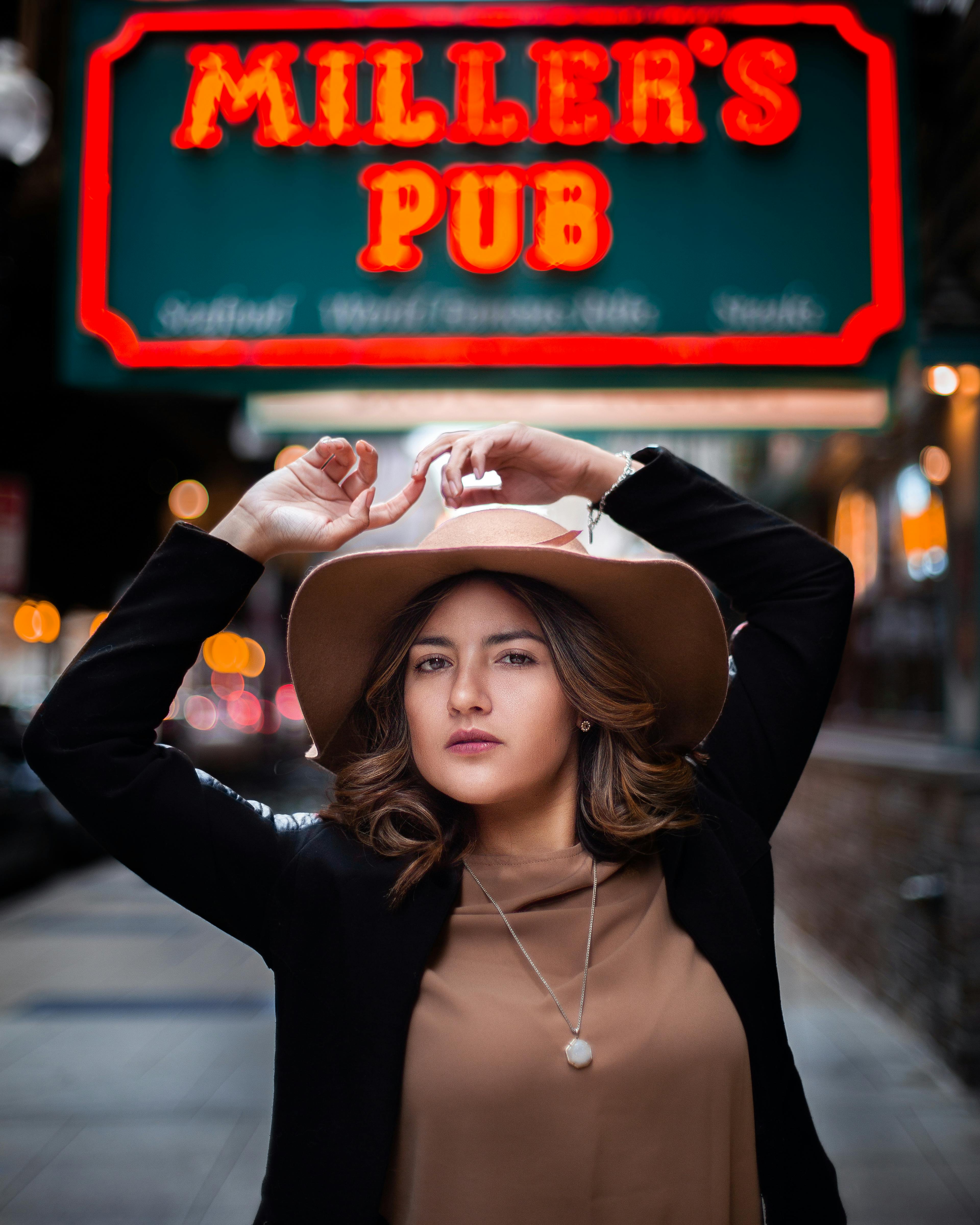 一位时尚女士自信地在米勒酒吧外摆姿势，展现都市时尚