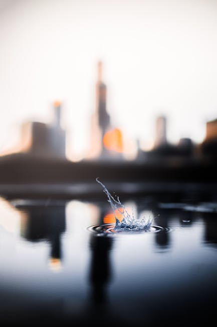 A captivating view of a water splash with a blurred city skyline in the background.