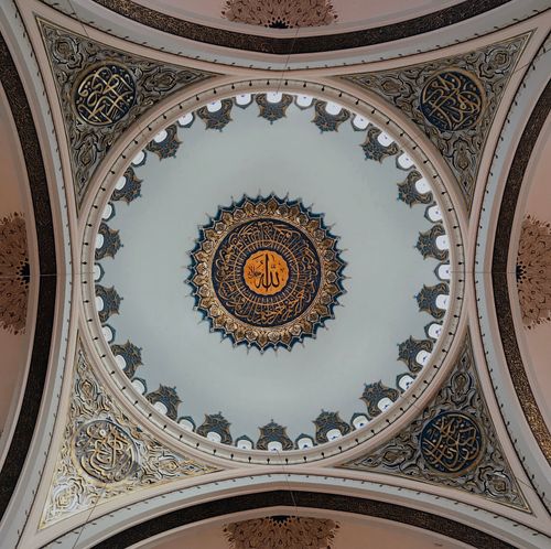 Free Exquisite mosque ceiling featuring ornate Arabic calligraphy and intricate designs. Stock Photo