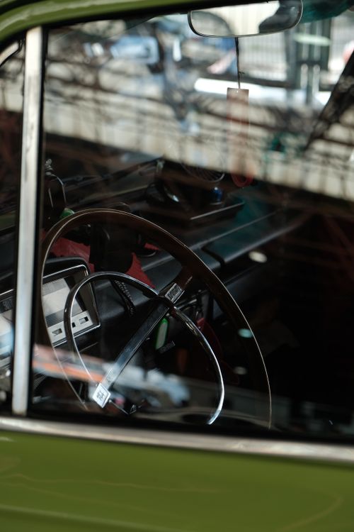 Free Close-up shot of a classic car's steering wheel viewed through the window. Stock Photo