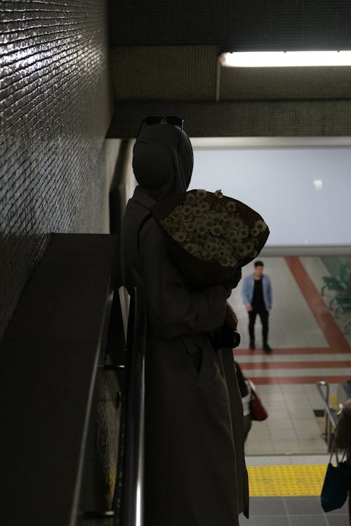 Woman Holding Bouquet on Station