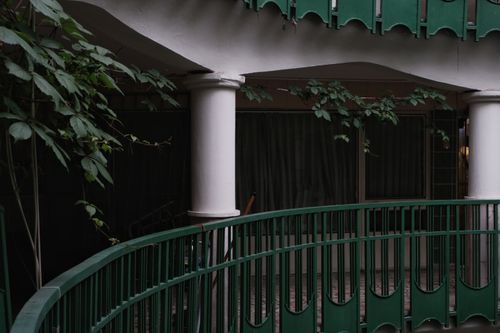 Free A modern urban balcony with green rails and white columns in an outdoor setting. Stock Photo