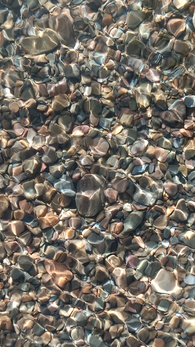 Small Pebble Seen Through Clear Water On A Beach