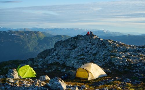 Free A captivating mountain camping scene with tents and rocky terrain under a clear sky. Stock Photo