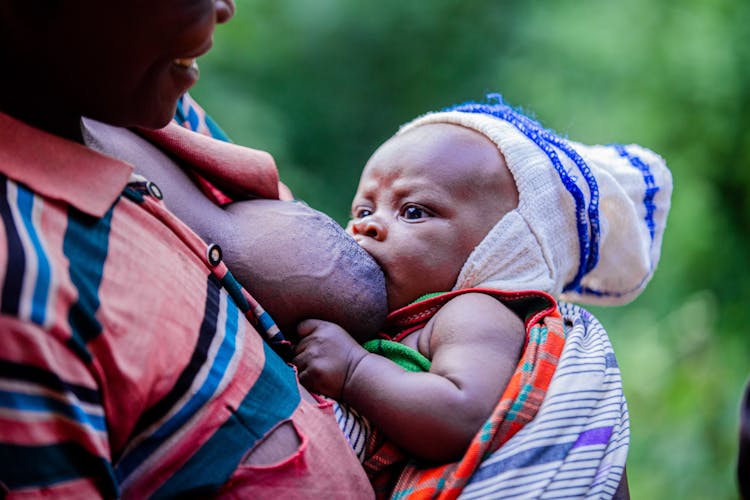 Mother Holding And Feeding Son