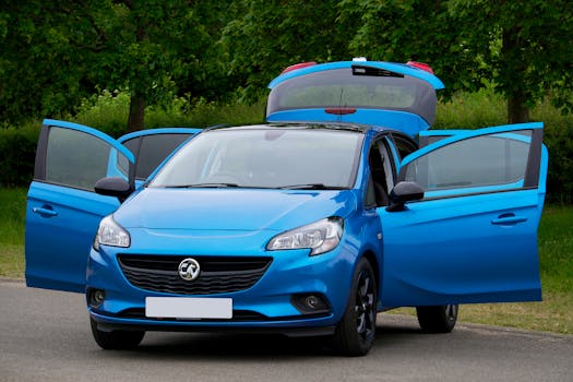 A vibrant blue car with open doors parked on a forest road, showcasing a lush green backdrop.