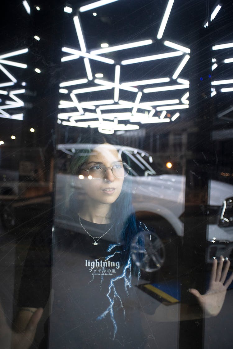 Reflection Of Woman In Eyeglasses In Window