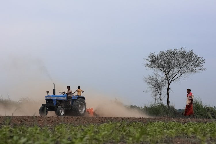 People On Tractor On A Field 