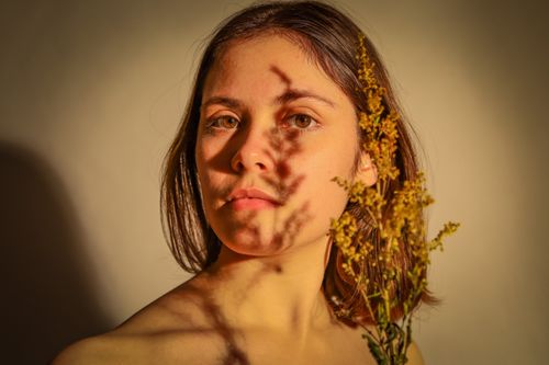 Free Elegant portrait of a woman with artistic shadows and floral elements. Stock Photo