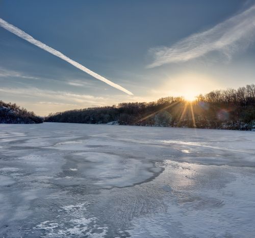 Free Stunning winter sunset over a frozen lake in Rochester, MN, showcasing nature's serene beauty. Stock Photo