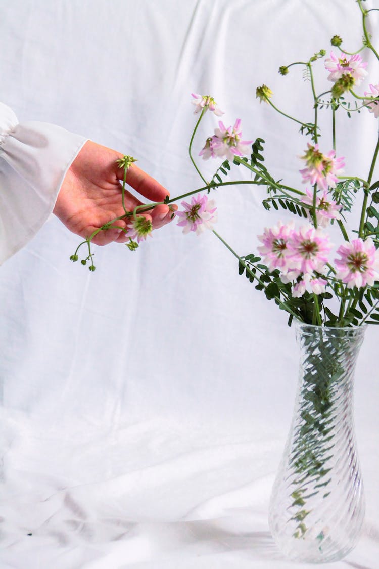 Woman Hand Touching Blooming Bouquet In Vase