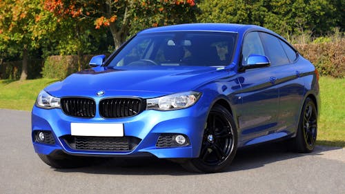 Free Blue Bmw Sedan Near Green Lawn Grass Stock Photo