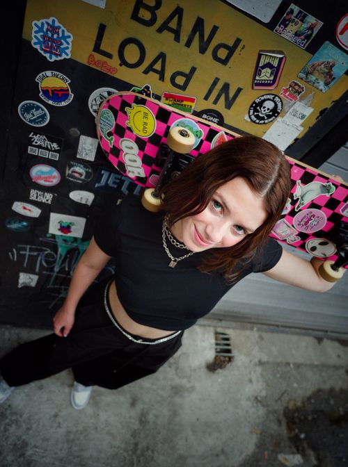 Free Young woman with pink skateboard, in a trendy outfit, at an urban skatepark. Stock Photo