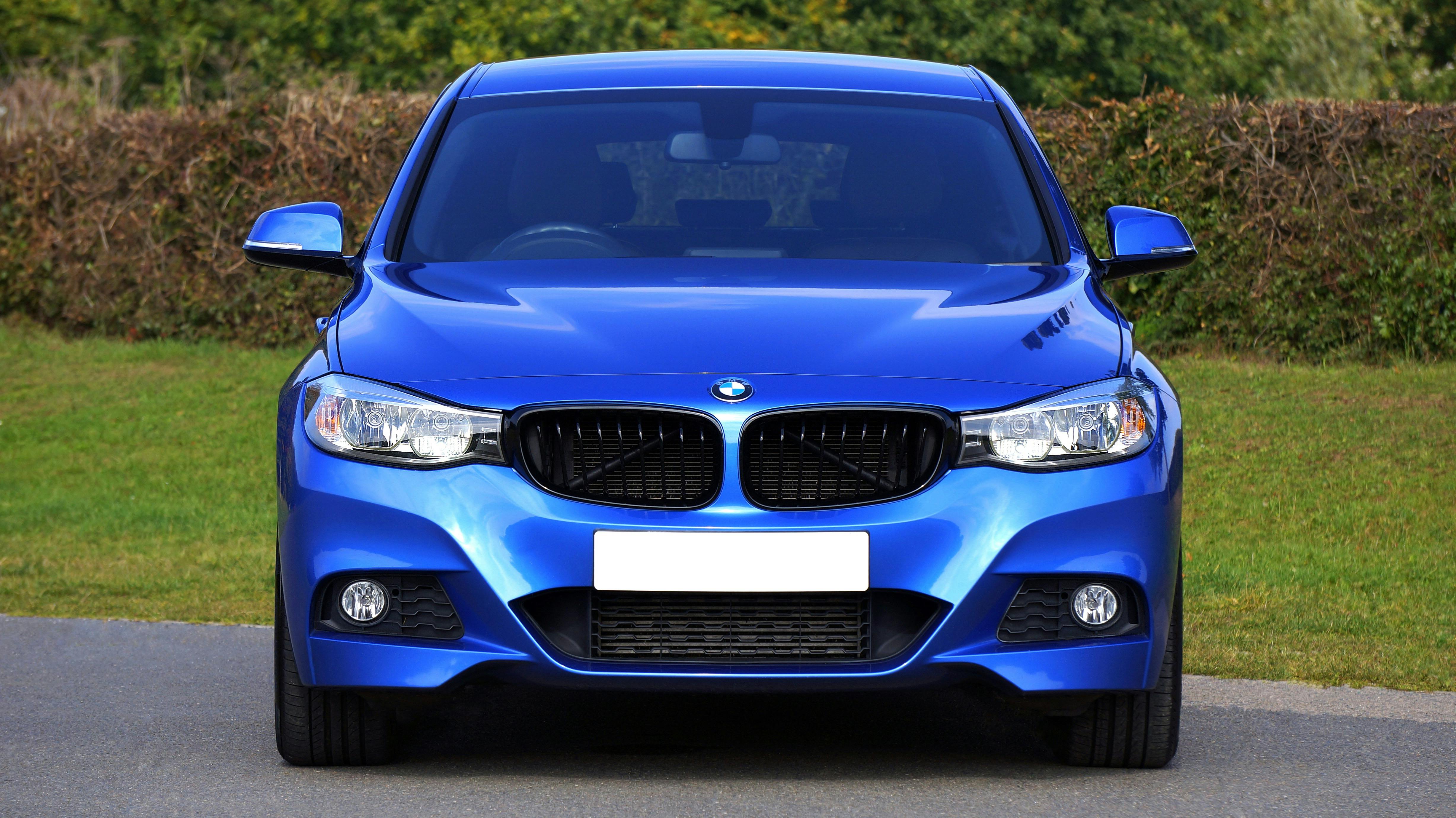 Blue Bmw Sedan Near Green Lawn Grass Free Stock Photo