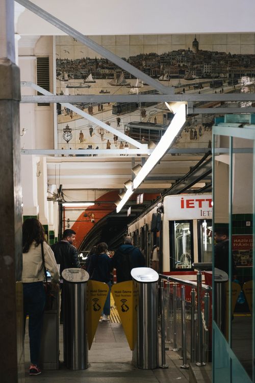 Free Passengers and vibrant decor at a bustling urban subway station captured in a lively daytime setting. Stock Photo