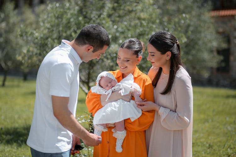 Smiling Women And Man With Baby