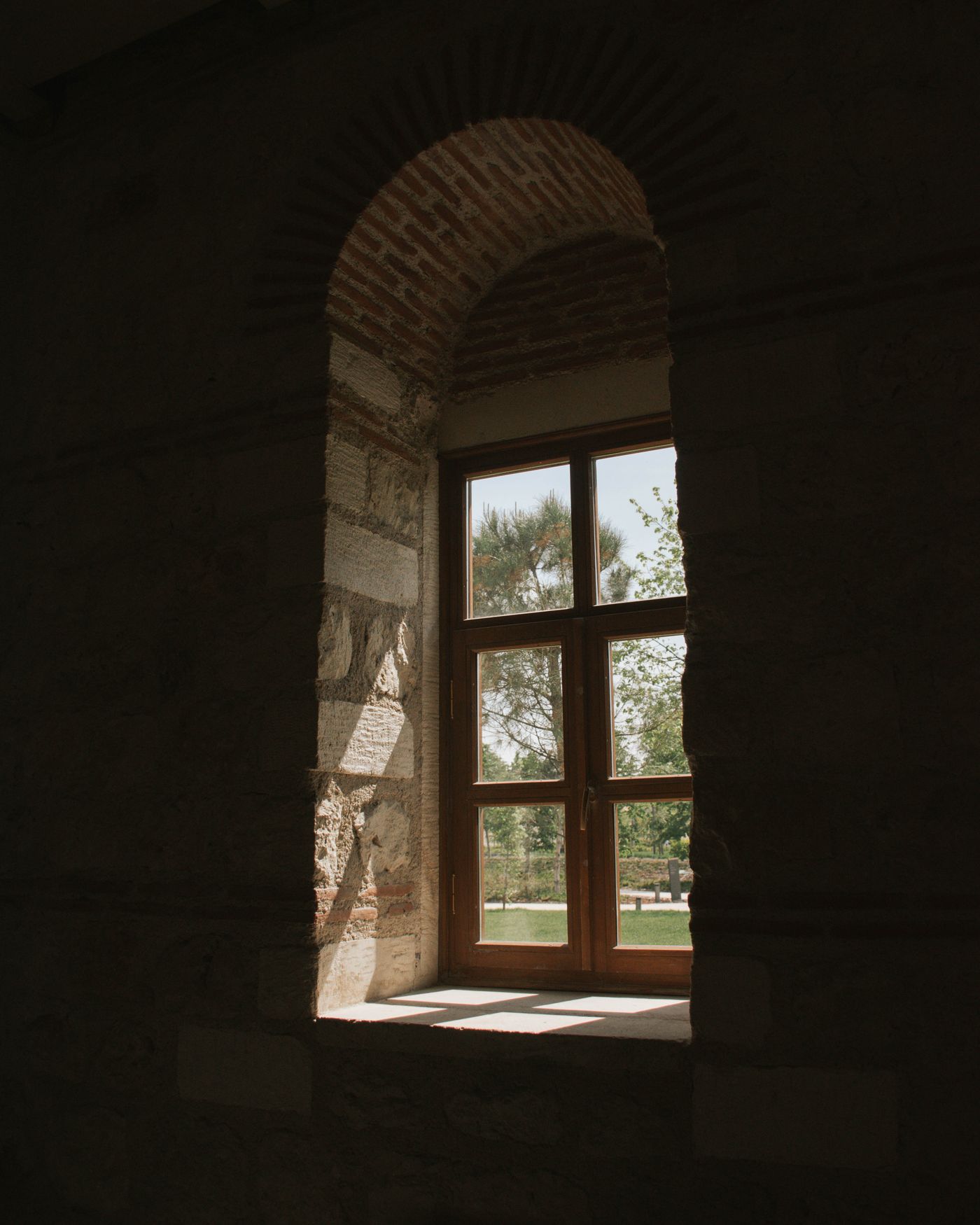 Sunlight streaming through an arched window of a historic stone building