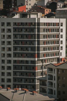 Tall modern apartment building in a bustling urban cityscape with contemporary design.