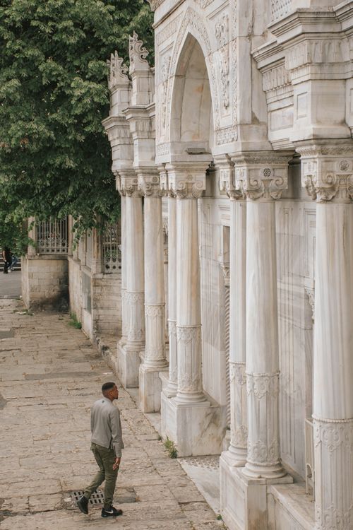 Free A man admires the elaborate marble columns of a historic building. Stock Photo