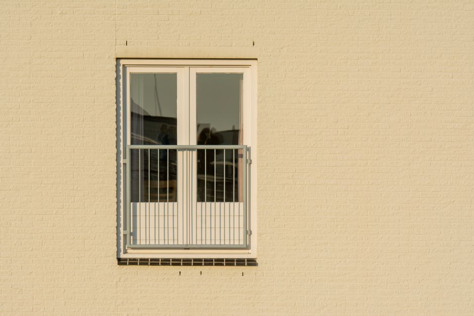 Kleiner moderner Balkon mit Klapptisch, zwei Stühlen und hellen Naturtönen als kompakter Essplatz
