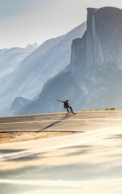 Skateboarder on Road in Mountains