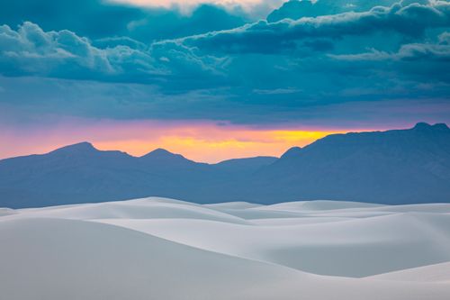 Free Stunning view of White Sands dunes at sunset with dramatic mountain backdrop. Stock Photo