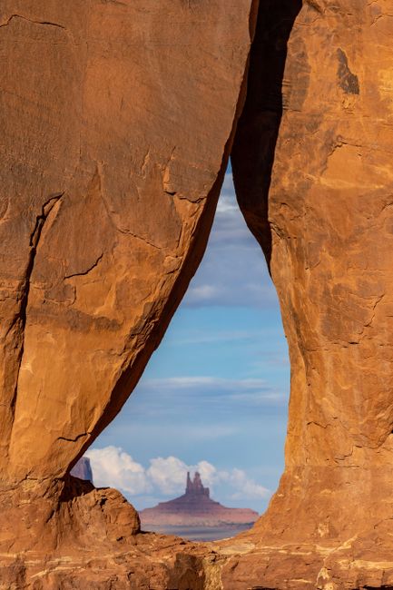 Breathtaking view of desert landscape framed by natural rock formation, showcasing unique geological shapes.